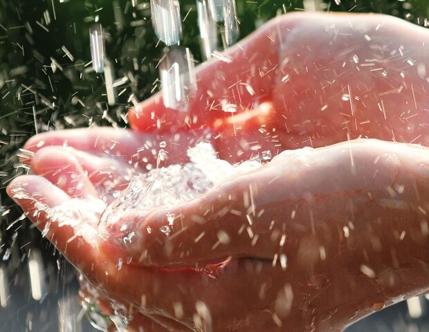 Eine Person hält ihre Hände unter fließendes Wasser.