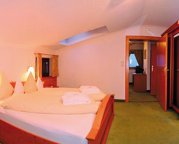 Hotelzimmer mit großem Doppelbett und Badezimmer.