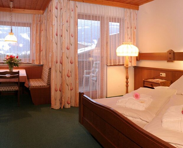Hotelzimmer mit Doppelbett, Fernseher und Esstisch.