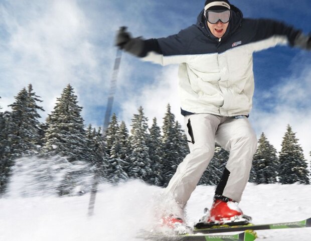 Ein Skifahrer fährt eine Piste hinunter.